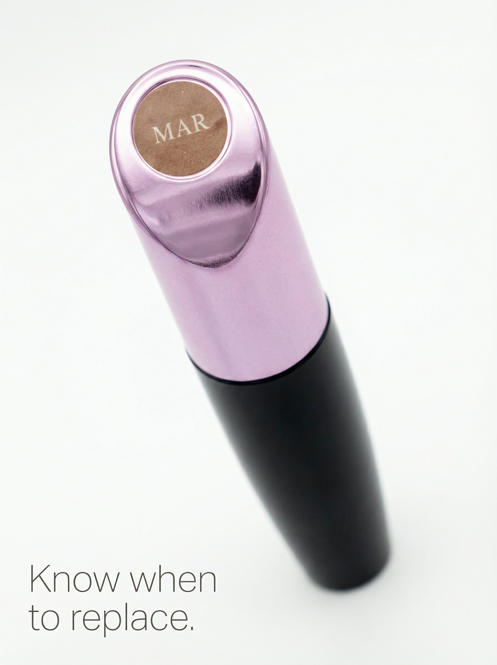 Black mascara tube with EyeVida month marker replacement sticker on white marble vanity.